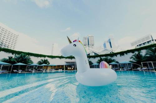 a white swan float in the middle of a pool at Pan Pacific Singapore in Singapore