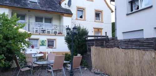 a patio with a table and chairs in front of a house at Boardinghouse Leiwen 46 in Leiwen