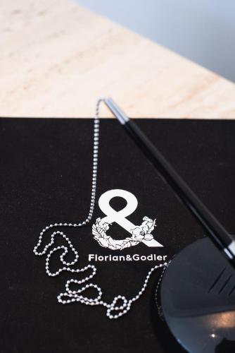 a close up of a necklace on a table with a mouse at Hotel Florian&Godler in Karlovac