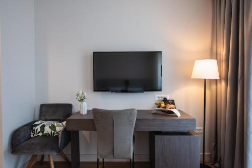 a room with a desk and a television on a wall at Hotel Florian&Godler in Karlovac