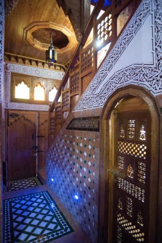 a staircase in a room with wooden walls and ceilings at Riad Mehdi Meknès in Meknès