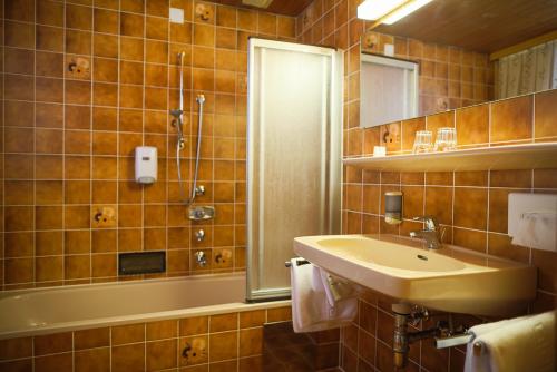 W łazience znajduje się umywalka i wanna. w obiekcie Hotel HAAS w mieście Bad Gastein