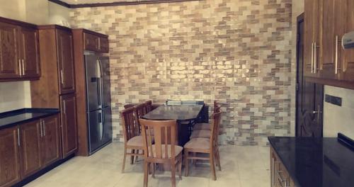 a kitchen with a table and chairs and a brick wall at Petra Villa in Wadi Musa