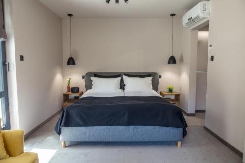 a bedroom with a blue bed and a yellow chair at Reverence Boutique Hotel in Varna City