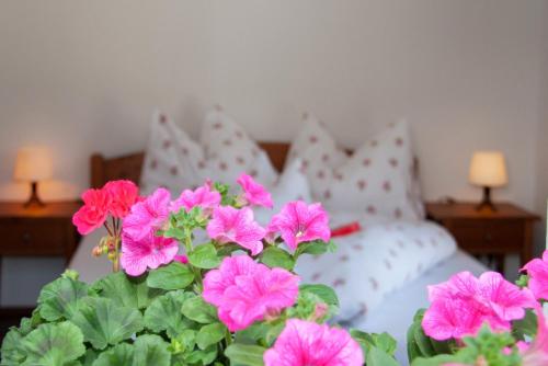 a bunch of pink flowers in front of a bed at Ferienwohnung Heissl in Fieberbrunn