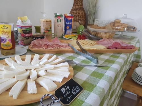 a table topped with cutting boards with meats and cheese at BIO Farma & Penzión Zlatý Hýľ in Nováčany