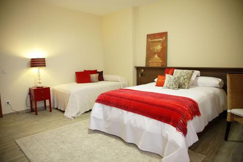 una habitación de hotel con 2 camas y una lámpara en Valle Del Eria Hotel, en Castrocontrigo