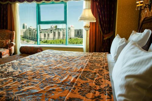 a hotel room with a bed and a window at Diplomat Hotel by AG Hotels Group in Astana