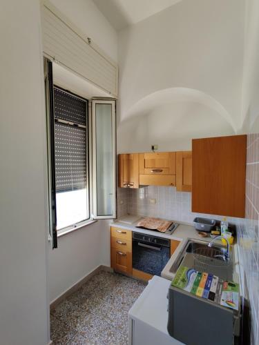 a kitchen with wooden cabinets and a sink and a window at Miramare palazzo Tamborino in Santa Cesarea Terme