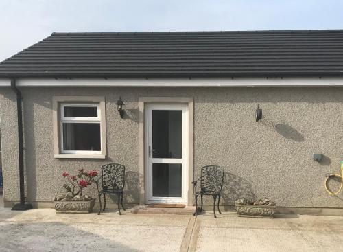 two chairs sitting in front of a house at Annslea in Lisburn