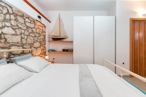 a bedroom with a stone wall and a bed at Meri in Premantura