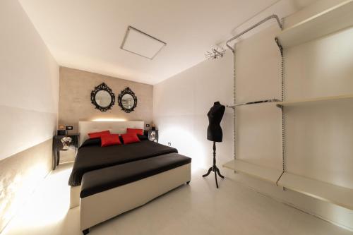 una camera da letto con un letto bianco e nero con cuscini rossi di Amuri Holiday Apartment a Cefalù