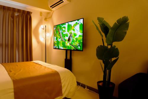 a bedroom with a bed and a flat screen tv at Premavera Kamata 303 in Tokyo