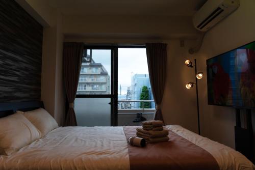 a bedroom with a bed with a large window at Premavera Kamata 303 in Tokyo