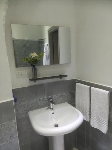 a bathroom with a white sink and a mirror at affittacamere BABY in La Spezia