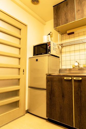 a kitchen with a refrigerator and a microwave at Premavera Kamata 303 in Tokyo