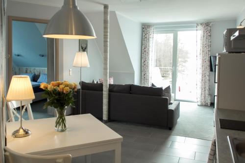 a living room with a couch and a table with a vase of flowers at Villa-Meehr in Bantikow