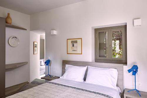 a bedroom with a large bed with a window at Nikolaou Art Residence in Aegina Town