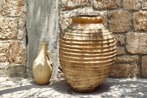 two vases are sitting next to a brick wall at Nikolaou Art Residence in Aegina Town