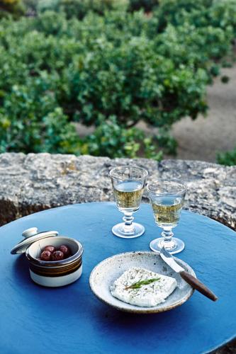 a table with two glasses of wine and a plate of food at Nikolaou Art Residence in Aegina Town