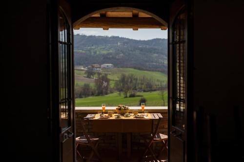 a dining room table with a view from an open window at Le Conche country house in Villamaina