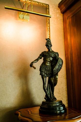 a bronze statue of a man standing on a table at Diplomat Hotel by AG Hotels Group in Astana