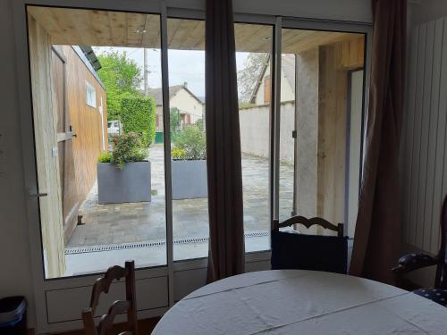 a room with a large window with a table and chairs at La grange des lisières in Rouvres