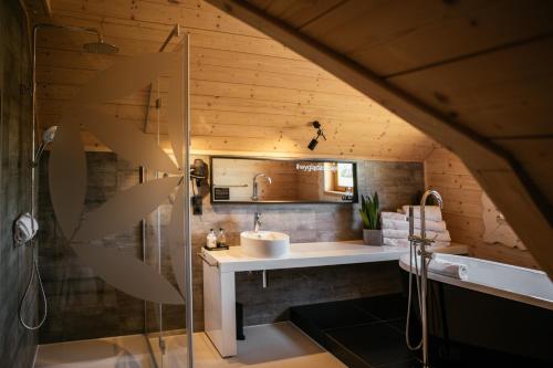 a bathroom with a sink and a shower at Bajka Hotel & Resort in Grodziec