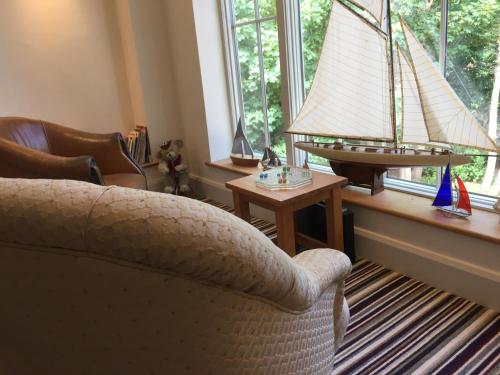 a living room with a couch and a toy boat in a window at Martlets B&B in Shanklin