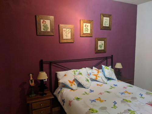 a bedroom with purple walls and a bed with pillows at Apartamento zona residencial Montesol in La Eliana