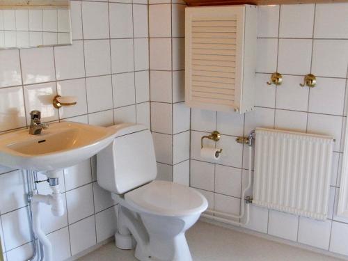La salle de bains est pourvue de toilettes blanches et d'un lavabo. dans l'établissement Two-Bedroom Holiday home in Väddö 1, à Veda