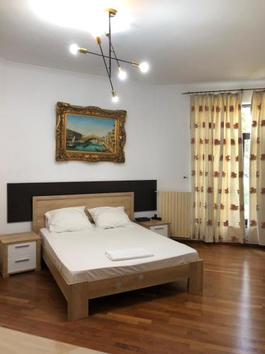 コンスタンツァにあるGarsoniera Alexandraのベッドルーム1室(ベッド1台付)が備わります。壁には絵画が飾られています。