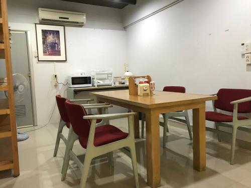 a room with a table, chairs, and a refrigerator at L42 Hostel Suvarnabhumi Airport in Lat Krabang
