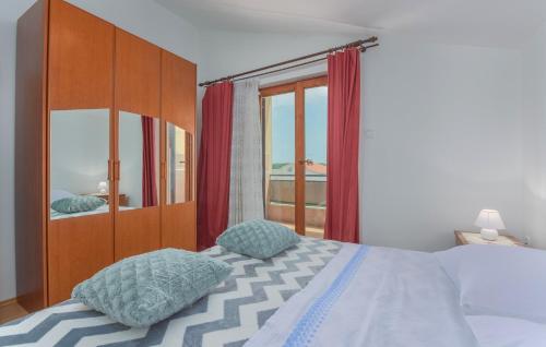 een slaapkamer met een bed en een groot raam bij Apartment Kristijan with Balcony in Funtana