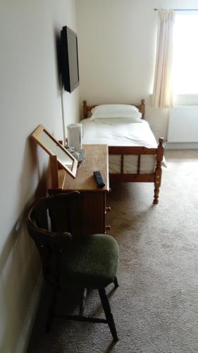 a bedroom with a desk and a bed and a chair at the old red lion in Bruton