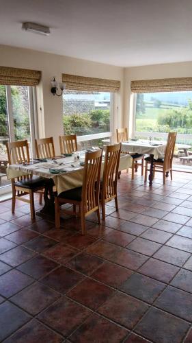 a dining room with a table and chairs and windows at the old red lion in Bruton