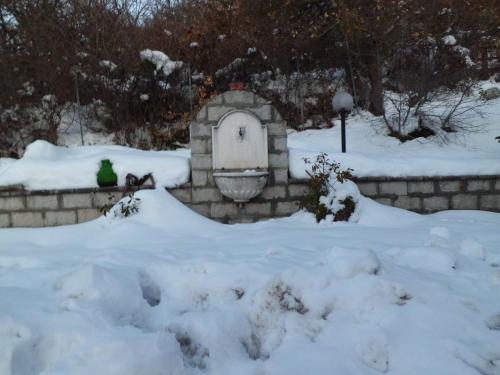 a bird sitting in front of a bird house in the snow at Casetta dei "Prati" in Vaglio di Basilicata