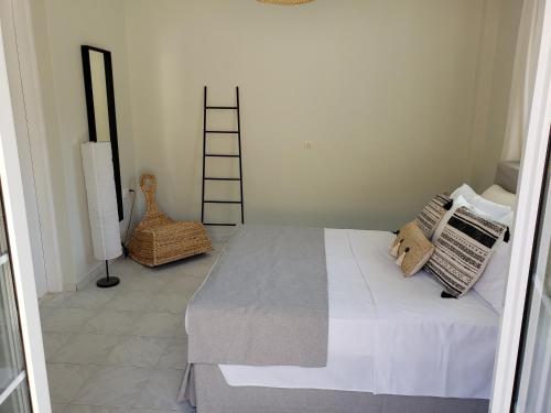 ein Schlafzimmer mit einem Bett und ein Zimmer mit einer Leiter in der Unterkunft Damatria studio in Karpathos