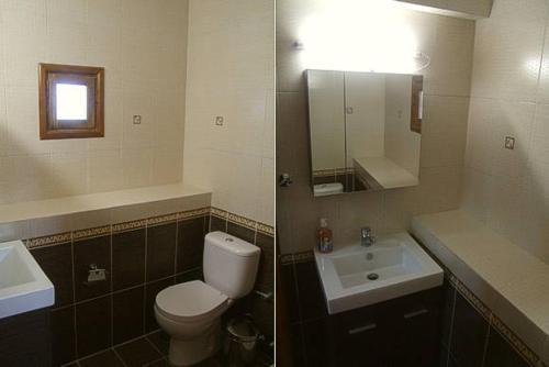 a bathroom with a toilet and a sink and a mirror at Nadia Apartments in Mithymna