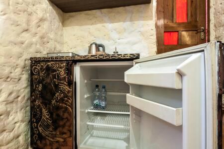 una nevera vacía con la puerta abierta en una cocina en Apartament Basarab en Leópolis