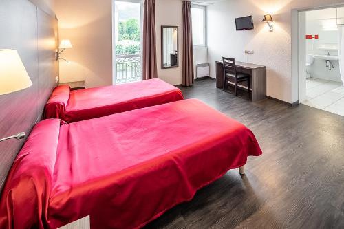 a hotel room with two beds and a bathroom at Hôtel Galilée Windsor in Lourdes