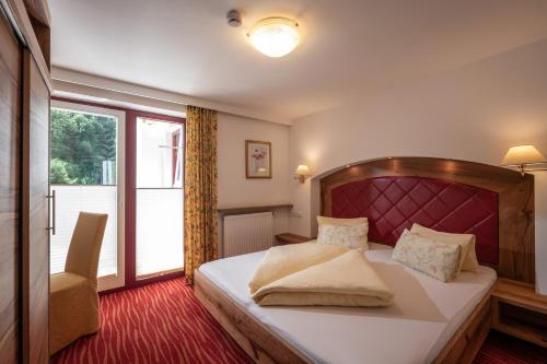 a bedroom with a large bed and a window at alpenrose hotel-garni in Gerlos