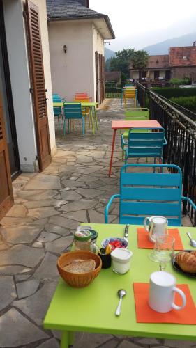 un groupe de tables et de chaises sur une terrasse dans l'établissement Le Curieux de Conques, à Saint-Cyprien-sur-Dourdou