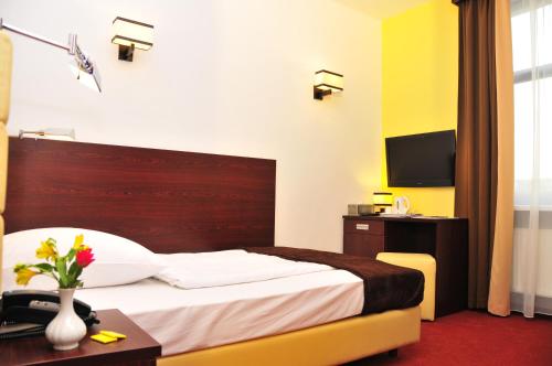 a bedroom with a bed and a desk and a television at Hotel City Inn Hamburg-Mitte in Hamburg