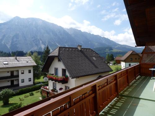 a balcony with a view of a house and mountains at Apartments Haus Steinbock in Tauplitz