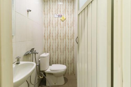 a bathroom with a toilet and a sink at House of Dharmawan in Surabaya
