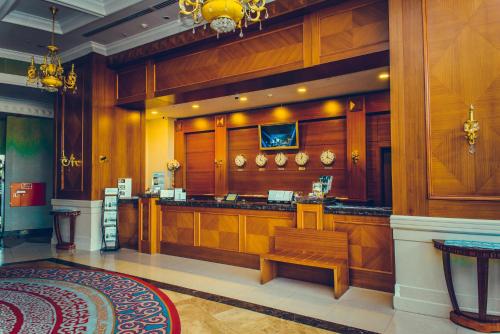 a restaurant with a bar with a bench in a room at Diplomat Hotel by AG Hotels Group in Astana