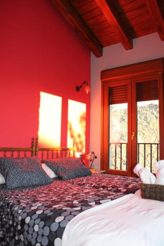 a bedroom with two beds with red walls and windows at Nekasenea II in Garísoain