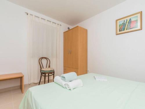 a bedroom with a bed with a chair and a cabinet at Apartment F-4 Klimno in Klimno