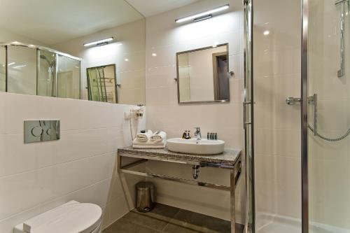 a bathroom with a sink and a shower and a toilet at Hotel Forza in Poznań